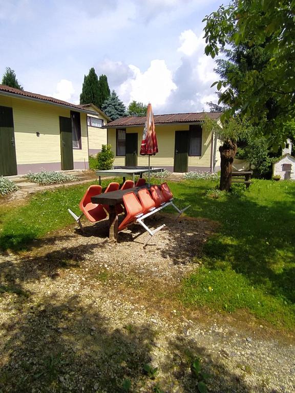a table and chairs and an umbrella in a yard at KEMPIN - KANTIN egyéb szálláshely in Bázakerettye