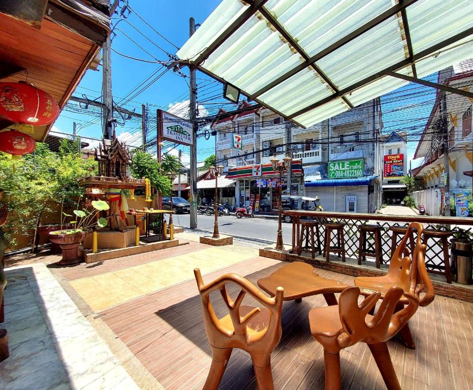 drewniany stół i krzesła przed ulicą w obiekcie Traveller Inn Hotel w mieście Chiang Mai