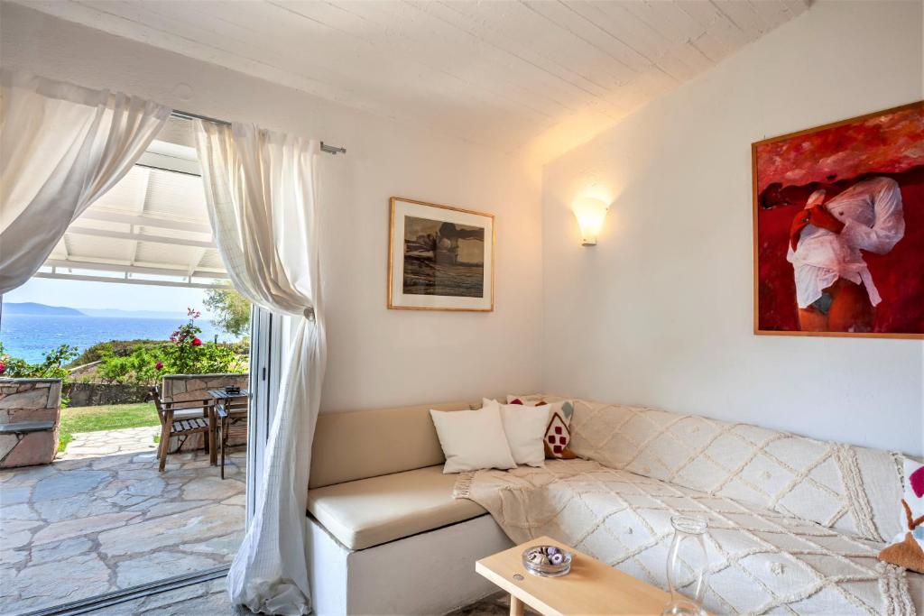 sala de estar con sofá y ventana grande en Alterra Vita Captain's Cabin en Neos Marmaras