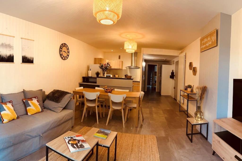 een woonkamer met een bank en een tafel bij Grand T2 renové, plein centre, 62 m² in Villard-de-Lans