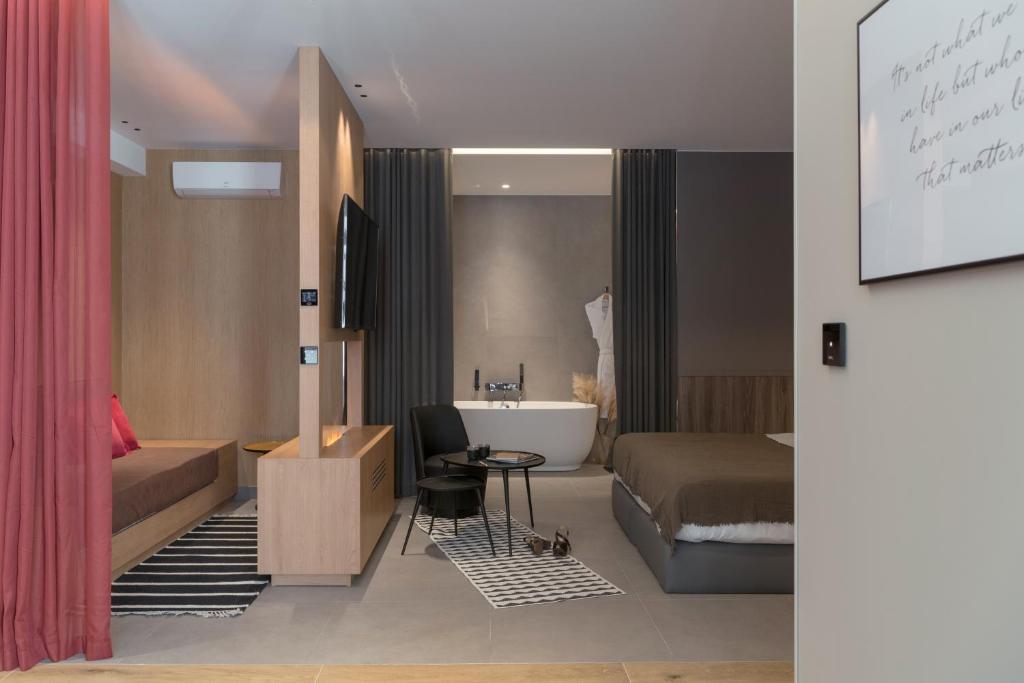 a hotel room with a bed and a tub and a sink at MiHotel Sala in Lyon