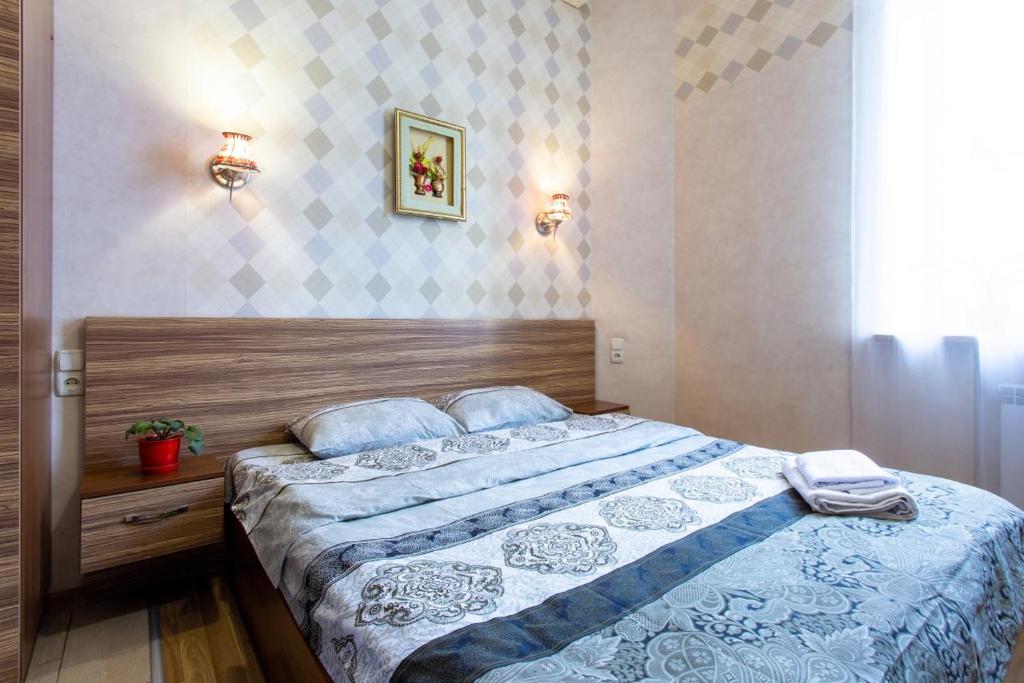 ein Schlafzimmer mit einem Bett mit einer blauen und weißen Decke in der Unterkunft Malon Apartments in Kharkov