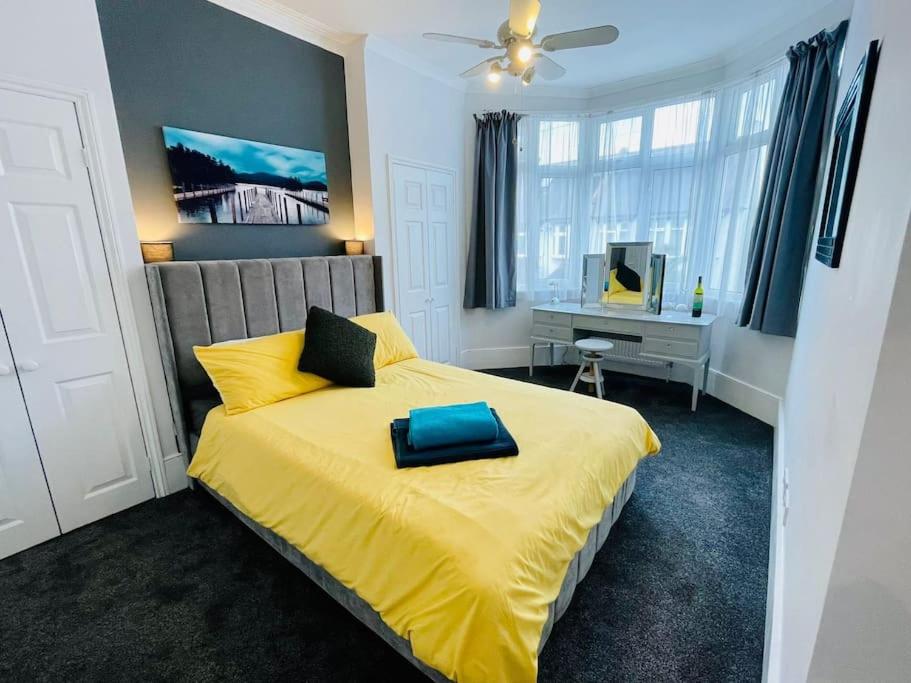 a bedroom with a yellow bed with a blue pillow on it at NEW modernised flat in the heart of Leigh on Sea in Southend-on-Sea