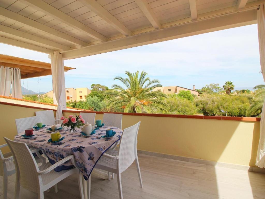 a dining room with a table and chairs on a balcony at Apartment in Costa Rei in Monte Nai