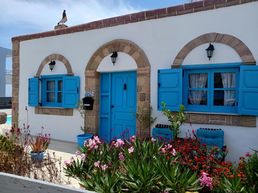 uma casa com portas e janelas azuis e flores em Villa Pavlina Gennadi em Gennadi