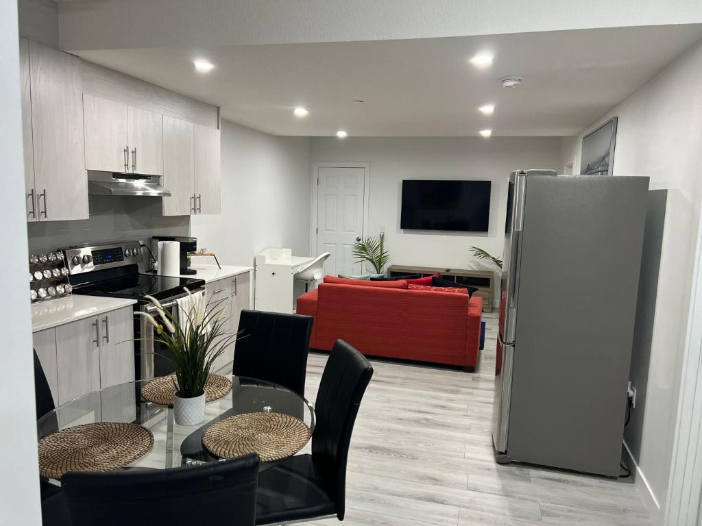 a kitchen and living room with a table and a refrigerator at Beautiful 2 bedroom home away from home in Calgary