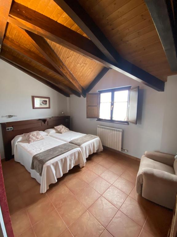 a large bedroom with two beds and a window at Hotel rural Monasterio de Ara Mada in Santa Colomba de las Arrimadas