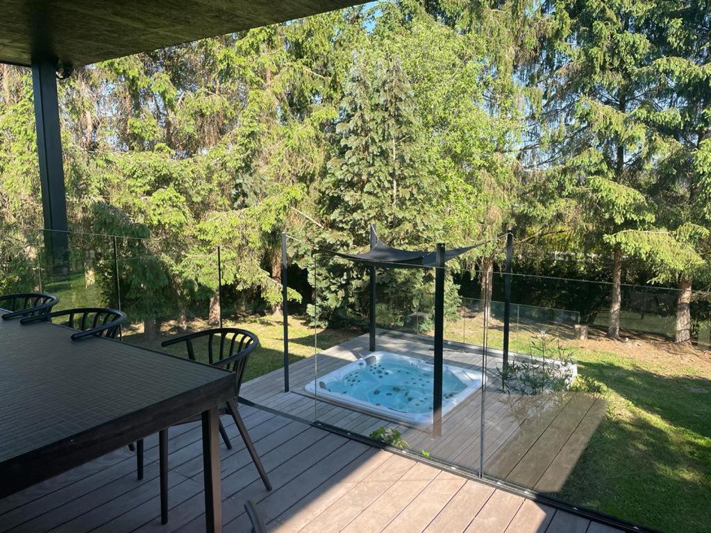 a patio with a hot tub with a table and chairs at Chez Arthur in Marche-en-Famenne