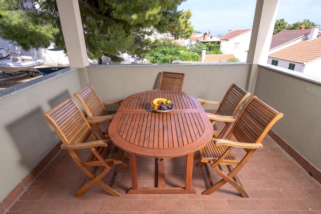 ボルにあるVilla Dalmatia Apartmentsの木製テーブル、バルコニー(椅子4脚付)