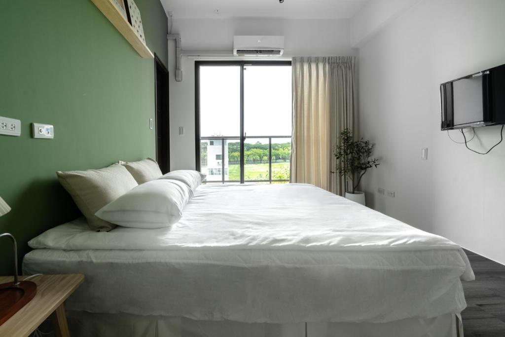 duże białe łóżko w pokoju z oknem w obiekcie The LINs House w mieście Guiren