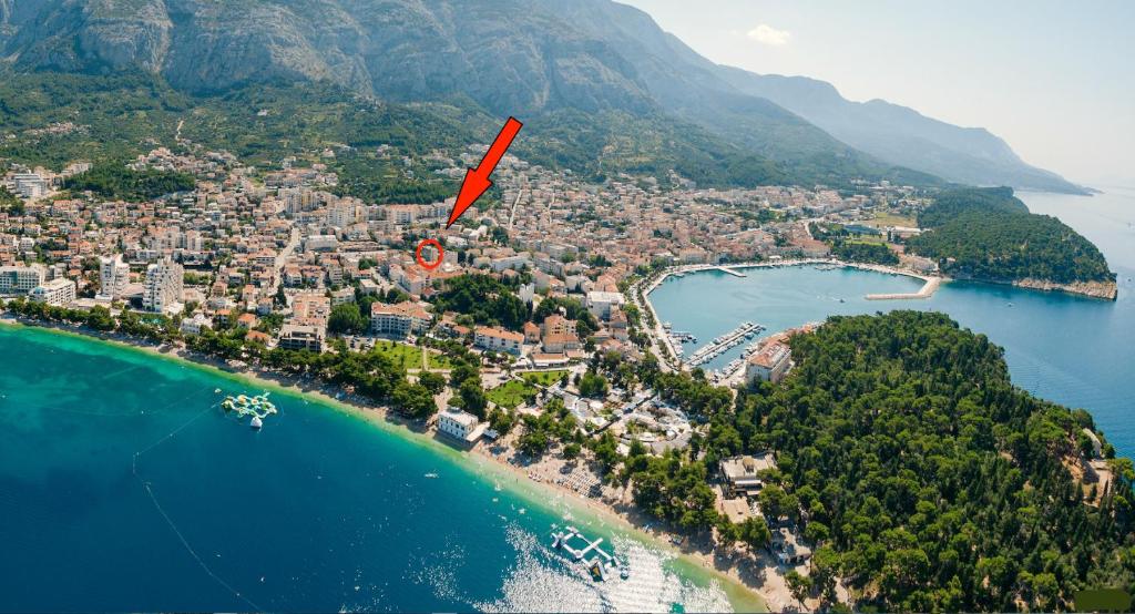 a red arrow pointing to a city on a beach at ADRIATIC APARTMENT center II MAKARSKA in Makarska