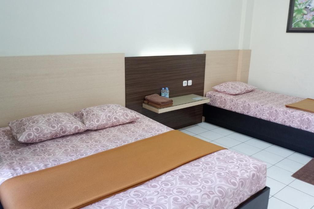 een kamer met 2 bedden in een kamer bij Hotel Taman Indah in Madiun