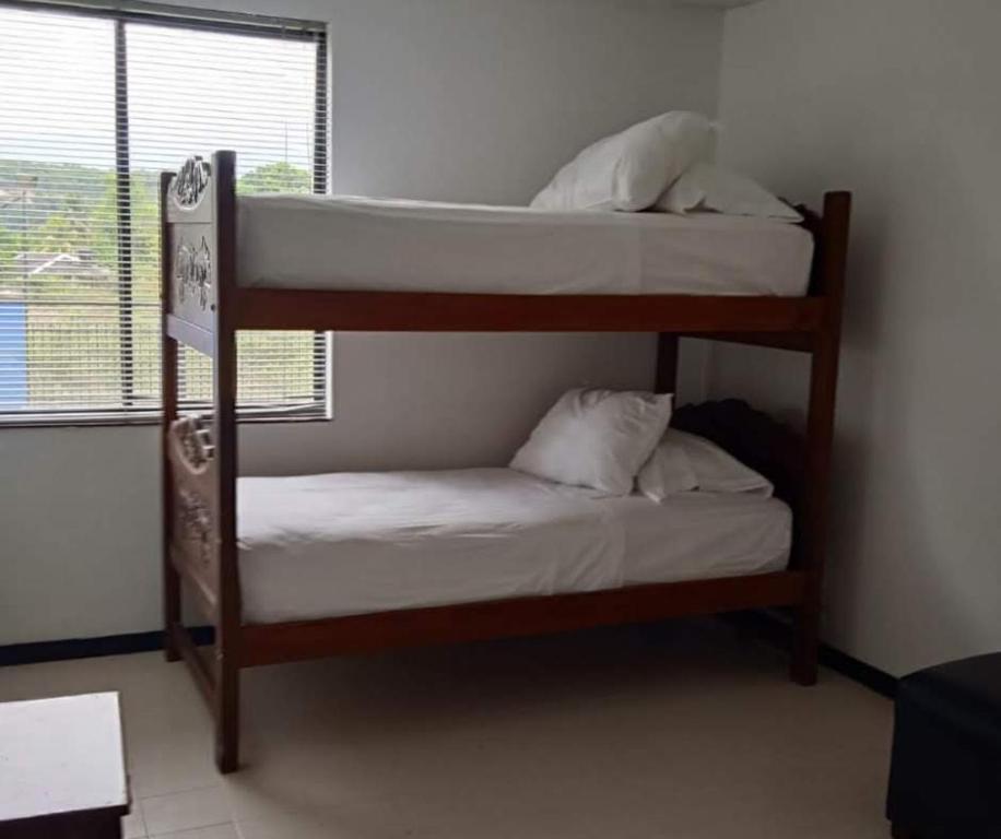 two bunk beds in a room with a window at Apartamento San José in Melgar