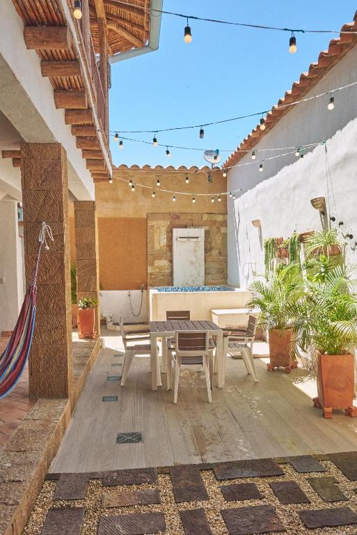 een patio met een houten tafel en stoelen bij Casa Pumata Barichara in Barichara