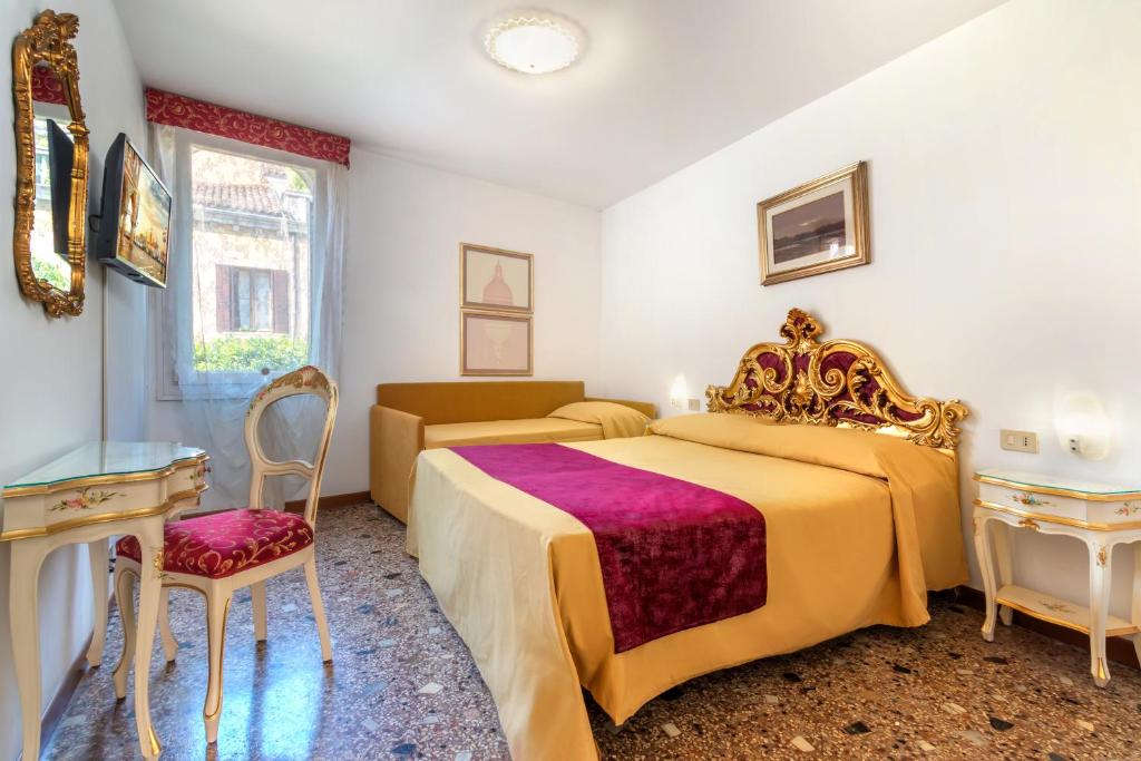 a bedroom with a king sized bed and a chair at Hotel Casa Boccassini in Venice