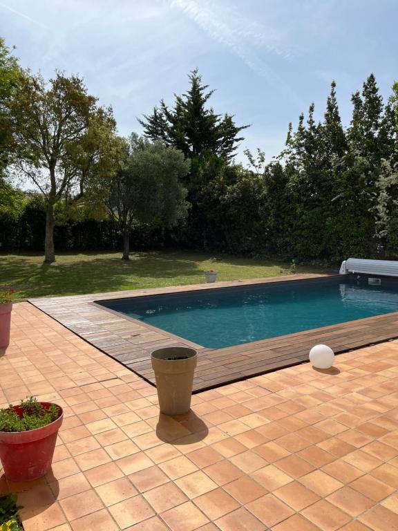- une piscine dans une cour avec des arbres et des buissons dans l'établissement Chambres d'hôtes Des Tours à La Rochelle, à La Rochelle