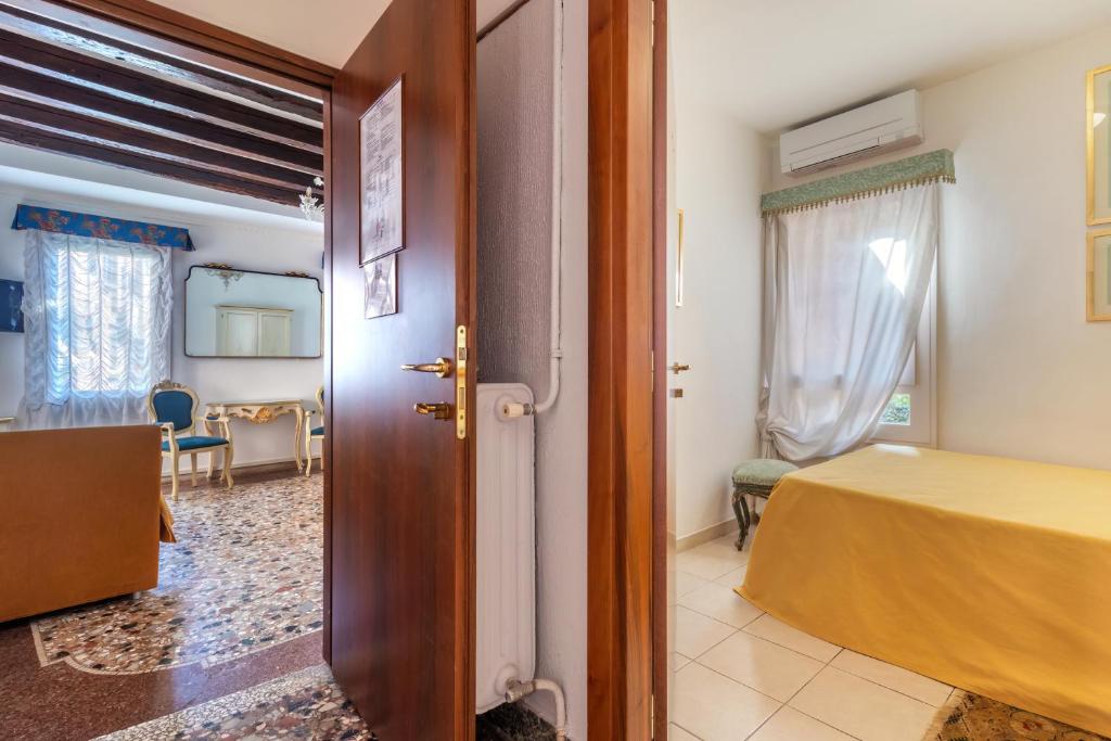 a room with a bed and a door leading to a bedroom at Hotel Casa Boccassini in Venice