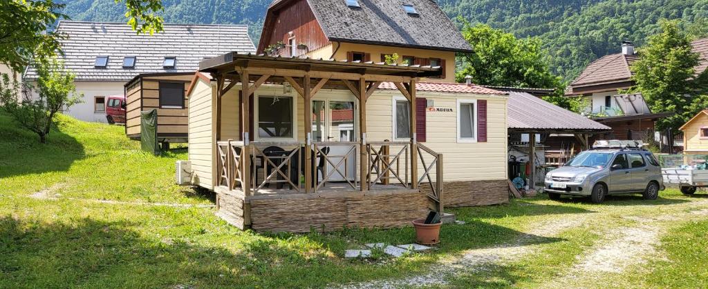 una casita en un patio al lado de una casa en Simonai Mobile Homes en Čezsoča