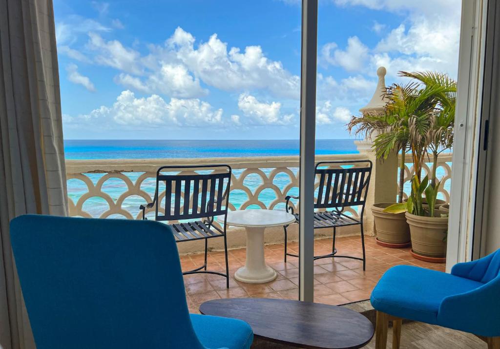 Un balcón con sillas y vista a la playa. en Beachside Apartments Cancun, en Cancún