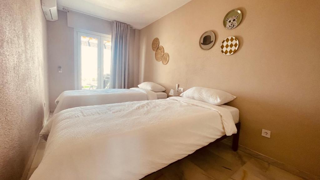 sypialnia z dwoma łóżkami i oknem w obiekcie Seaview Apartment Mira Andalus w mieście Sitio de Calahonda