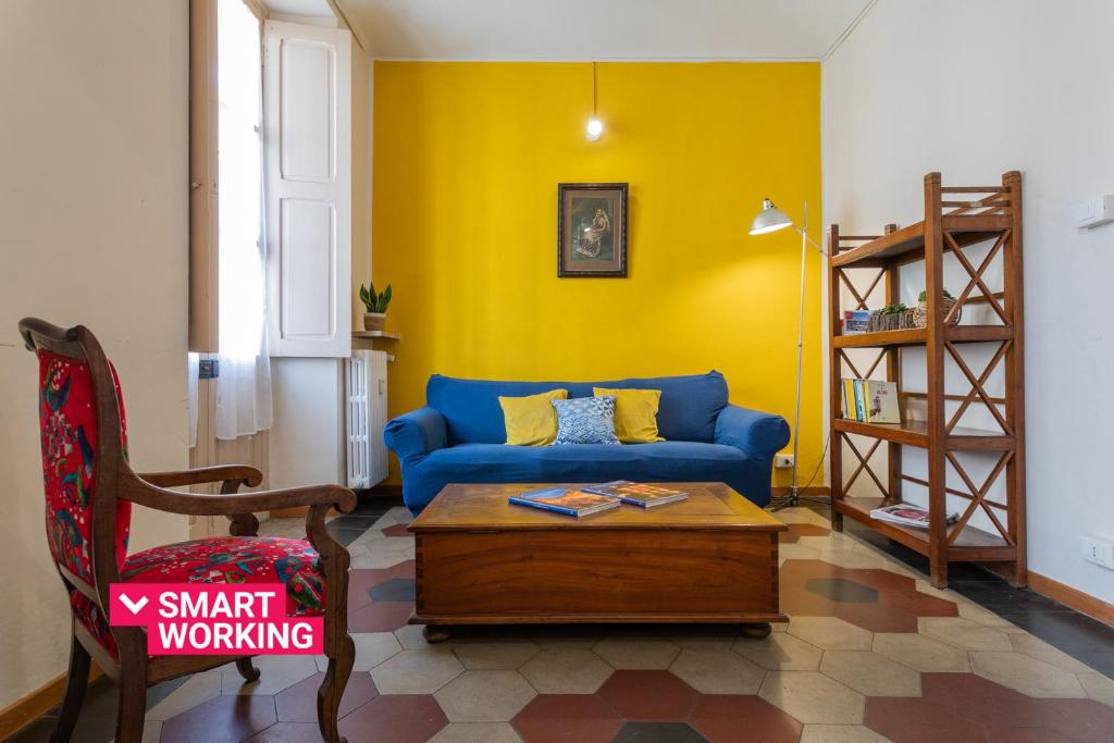 sala de estar con sofá azul y pared amarilla en Vintage Apartment in Lingotto Area by Wonderful Italy, en Turín