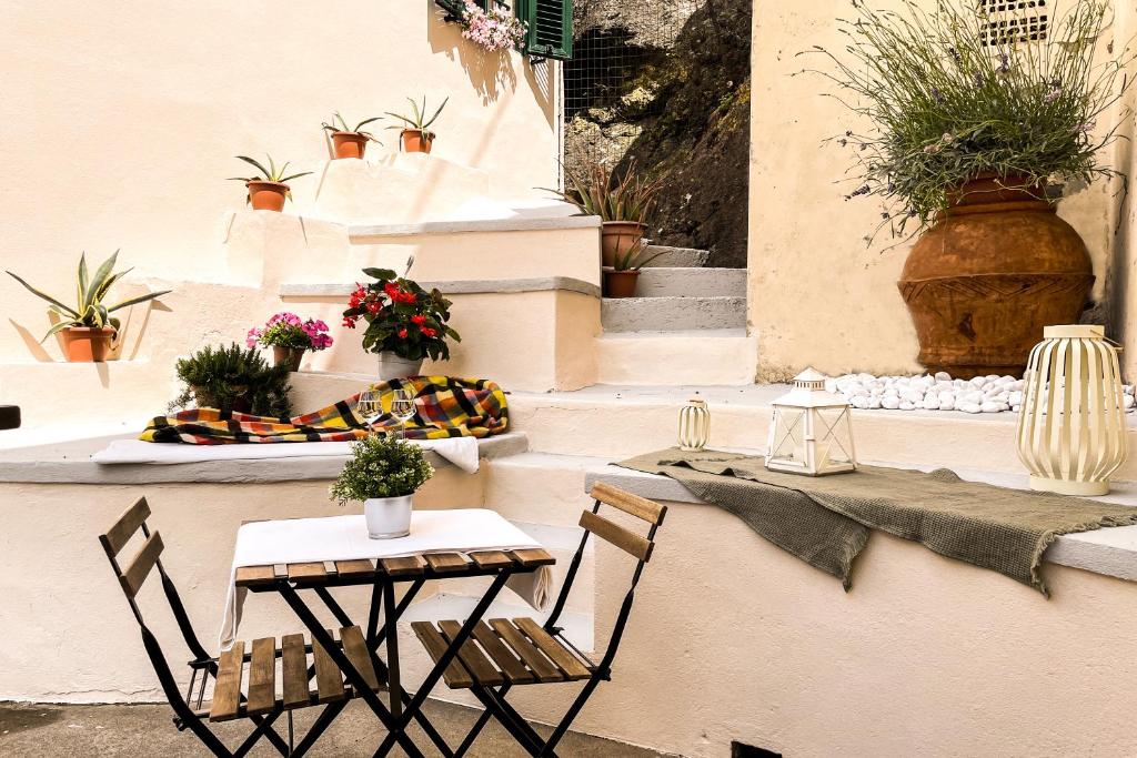 due sedie e un tavolo e alcune piante in vaso di Casa storica con terrazzo a Castellina Marittima