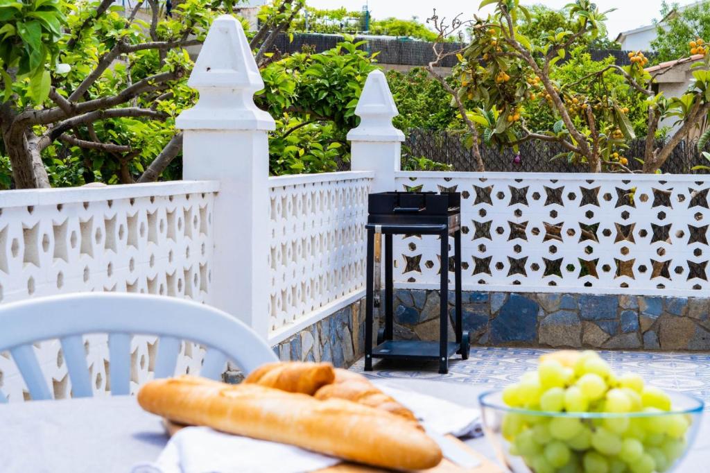 a table with a bowl of bread and grapes at Villa Felicidad in Vilanova i la Geltrú