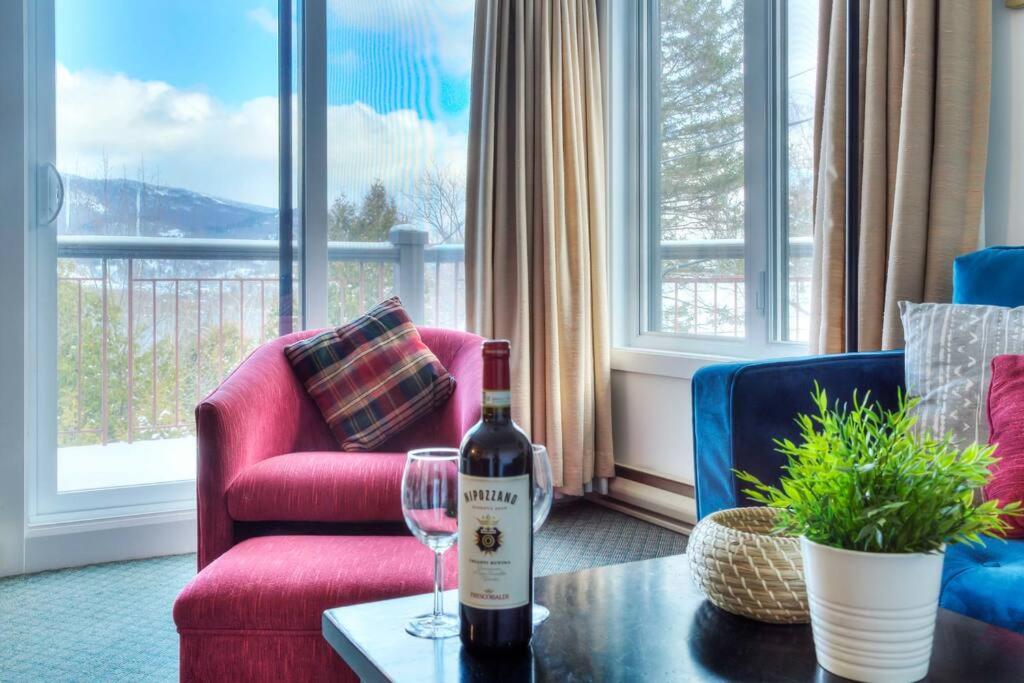 eine Flasche Wein auf dem Tisch im Wohnzimmer in der Unterkunft Tremblant Mountain Resort Condo! in Mont-Tremblant