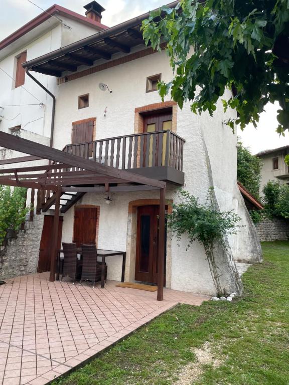 een huis met een terras en een patio bij Tipico rustico in pietra friulana in Budoia