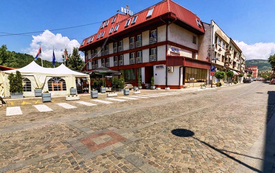 a building with a red roof on the side of a street at Hotel Sax Balkan in Dimitrovgrad