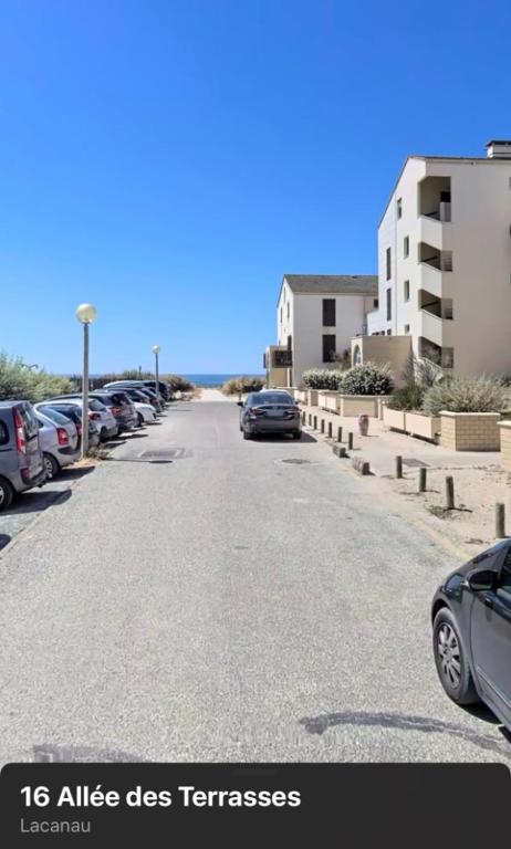 une rue avec des voitures garées dans un parking dans l'établissement Happy Place, à Lacanau