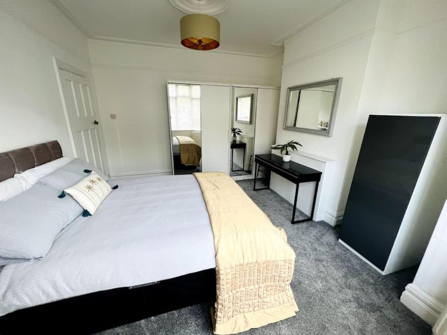 a bedroom with a large bed and a desk at Perfect Location Whole Apartment With Wifi & Private Garden CONTRACTORS WELCOME in Southend-on-Sea