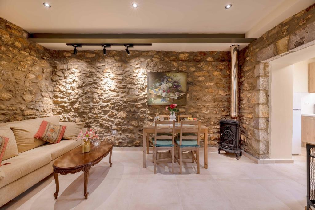 a living room with a couch and a table at Eftichia's Nomad stone house in Dhouvraíika