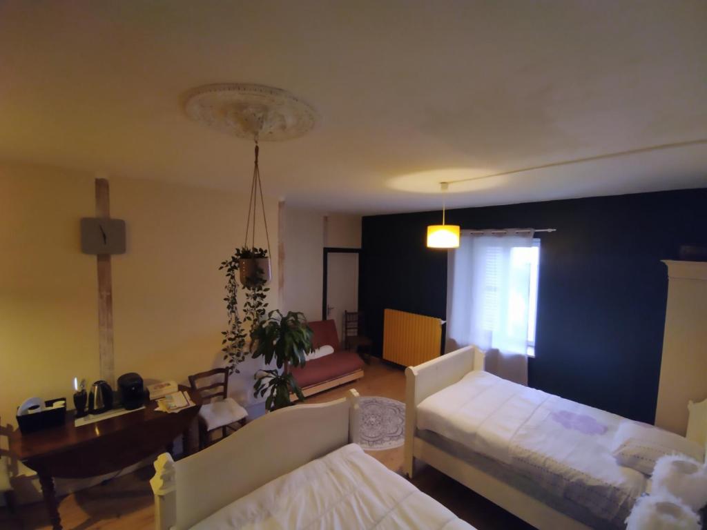 een woonkamer met een bed en een eetkamer bij Charmante chambre dans village jurassien 