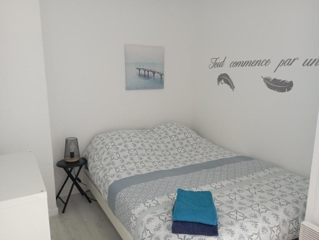 een slaapkamer met een bed met een blauw kussen erop bij Le Pornizhan in Pornichet
