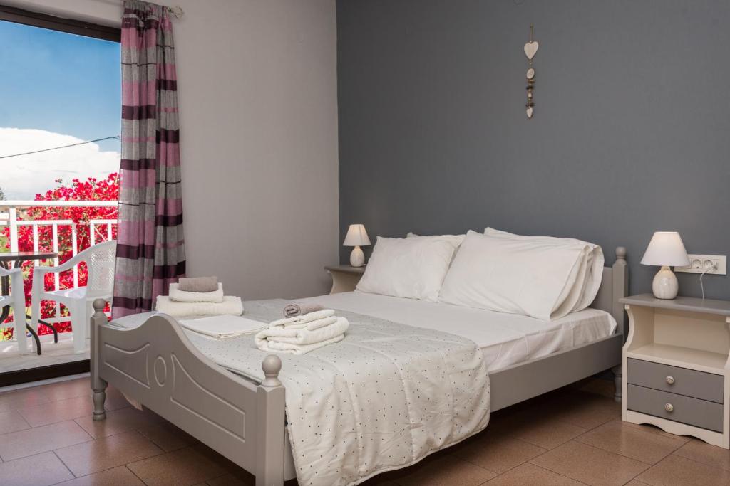 a bedroom with a bed with towels on it at Theodora Studios in Argasi