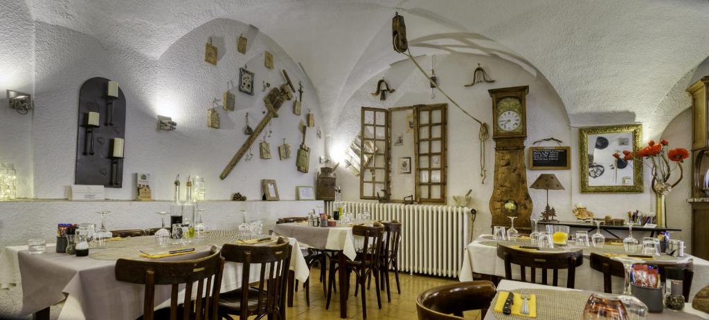 a restaurant with tables and chairs and a clock on the wall at Hotel Pascal in Allos