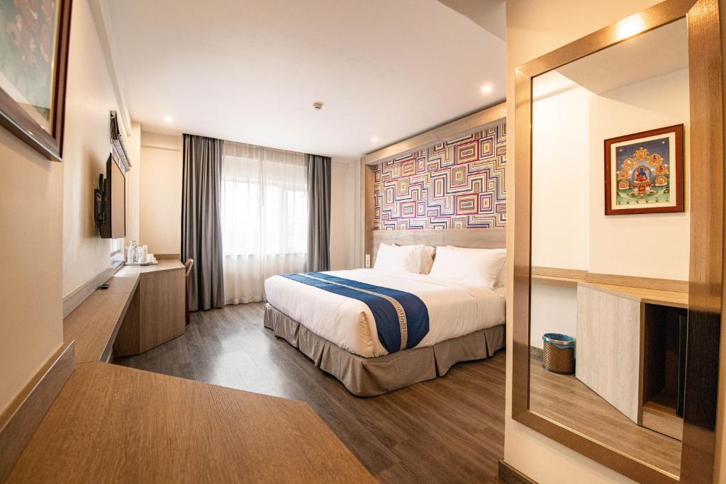 a hotel room with a bed and a mirror at Mila Hotel in Kathmandu