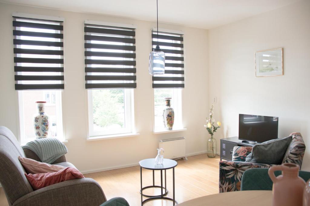 een woonkamer met 2 stoelen en een televisie bij Gastenverblijf Janssen in Schagen (NH) in Schagen