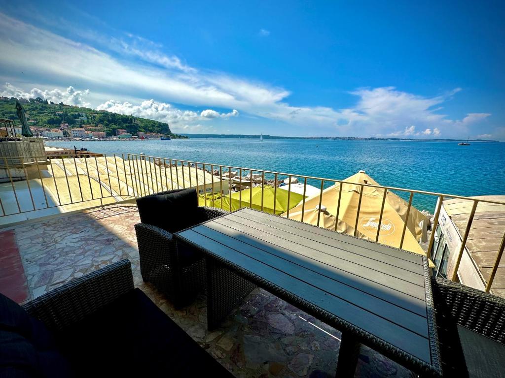 un banco sentado en un balcón con vistas al agua en SeaHouse Apartments, en Piran