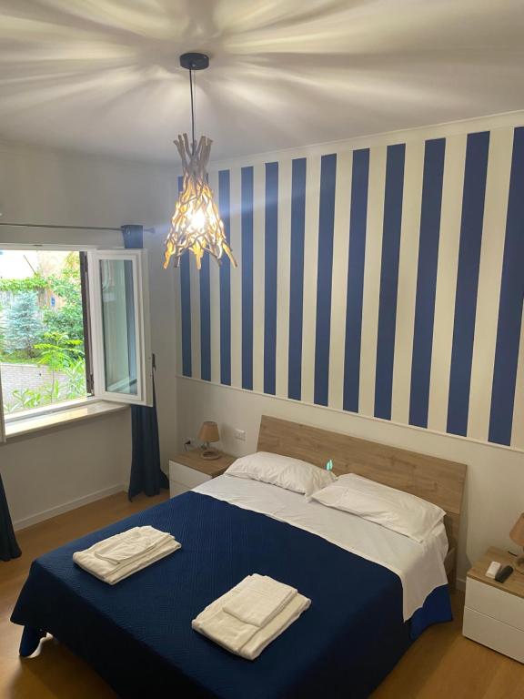 sypialnia z łóżkiem z niebieskimi i białymi paskami w obiekcie IL FARO in centro vicino Pompei Amalfi Sorrento w mieście Castellammare di Stabia