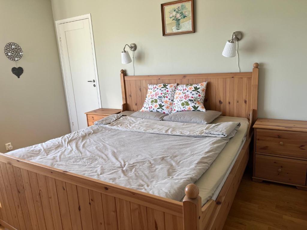a large bed with a wooden frame in a bedroom at An entire floor in a beautiful villa, close to Arlanda Airport in Stockholm
