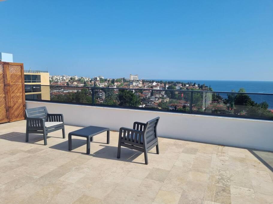 2 Bänke und ein Tisch auf einem Balkon mit Meerblick in der Unterkunft Royal Homes 503 in Antalya
