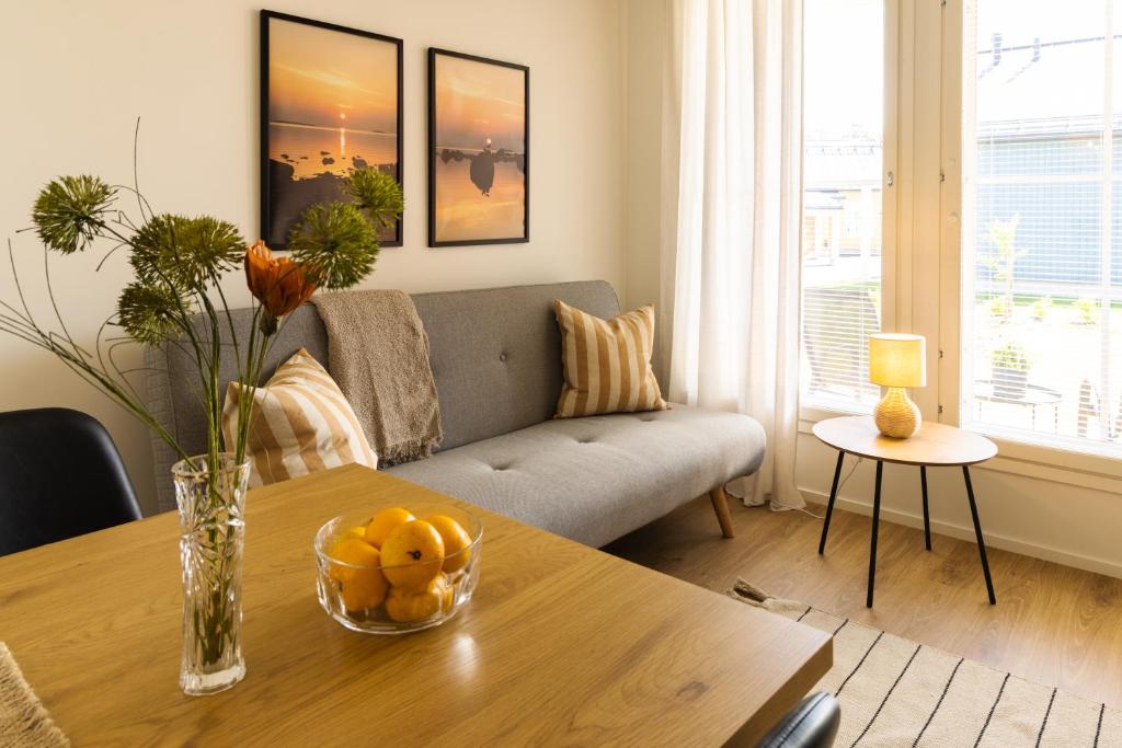 a living room with a table and a couch at Ihastuttava luhtitaloyksiö in Kokkola