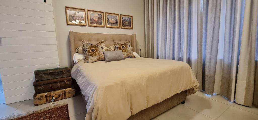 a bedroom with a bed with pillows on it at Luxury Cottage - Malmesbury in Malmesbury