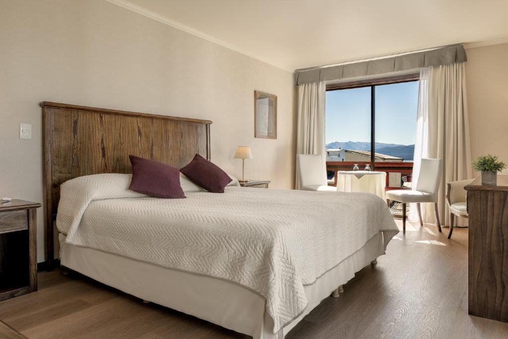 a bedroom with a large bed and a large window at Soft Bariloche Hotel in San Carlos de Bariloche