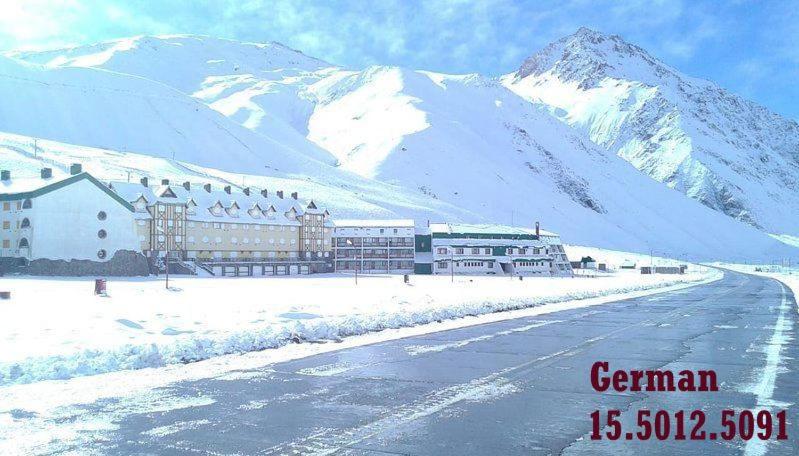 a hotel in the snow with a mountain in the background at Hermoso departamento frente a las montañas in Los Penitentes