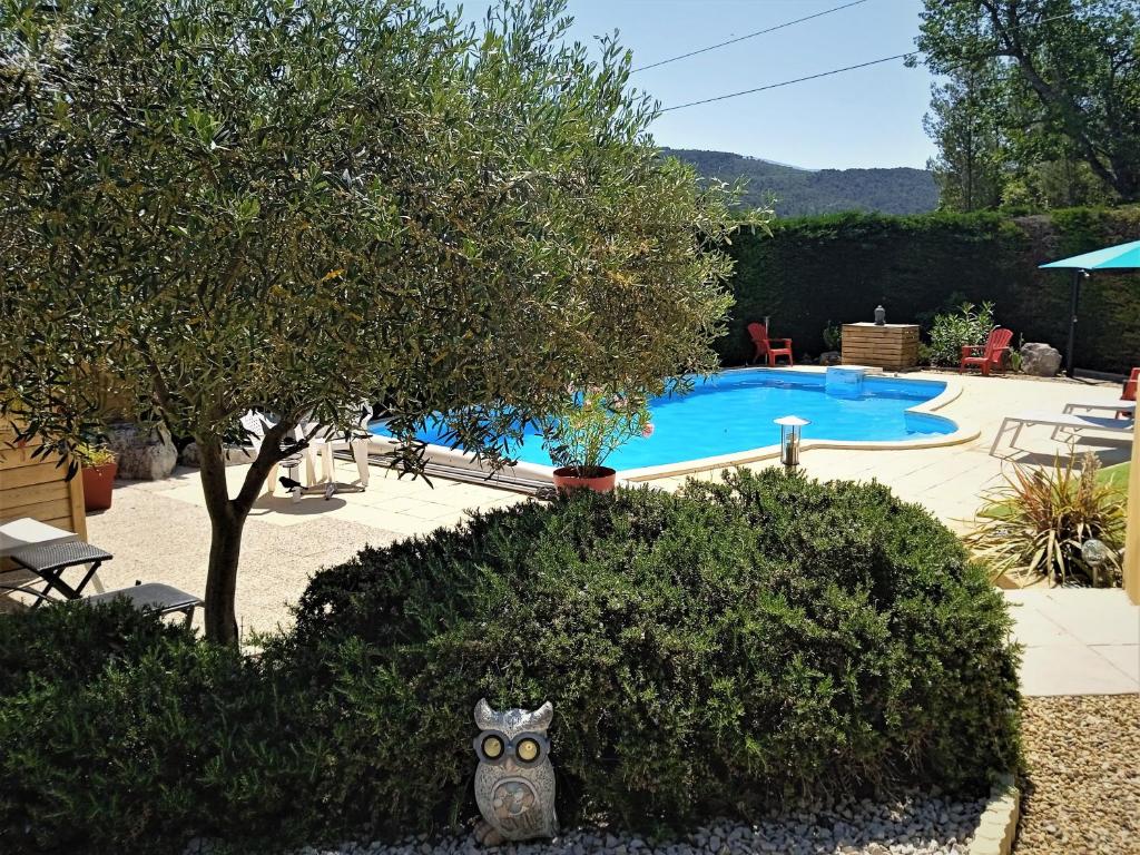 um jardim com uma estátua de gato ao lado de uma piscina em AU VILLADIOR - Vaison la Romaine em Vaison-la-Romaine