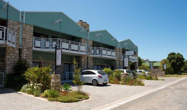 een auto geparkeerd op een parkeerplaats voor een gebouw bij Osler Place Self-Catering in Stilbaai