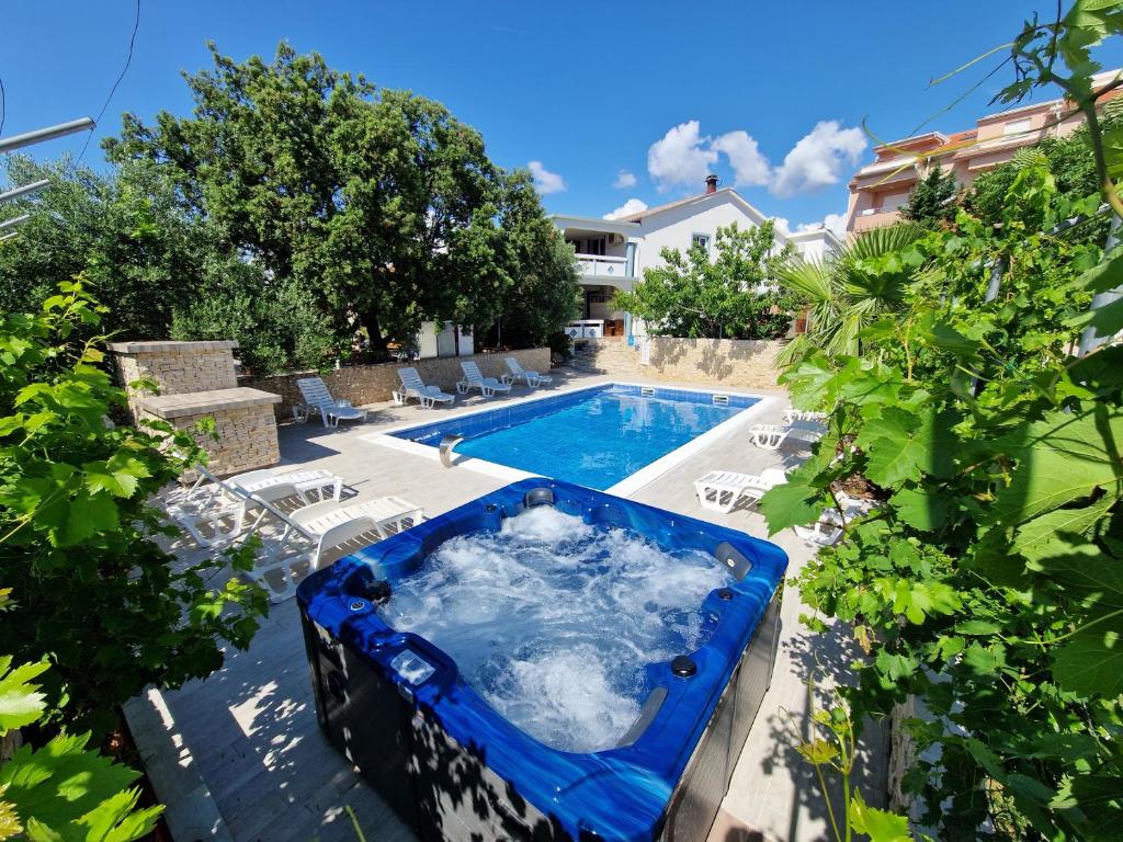 a swimming pool with a blue tub in a yard at Pool Apartment Knezevic in Novalja